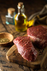 Raw beef steaks on a wooden desk