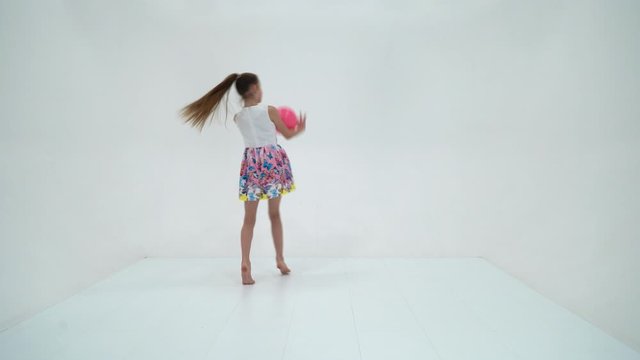 little girl is engaged in fitness with a ball.