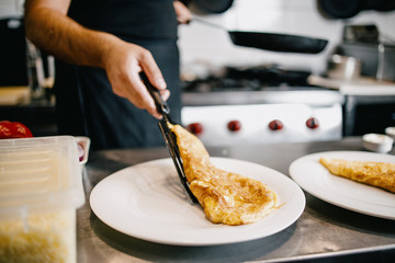 Professional chef working in restaurant kitchen and making delicious traditional food.