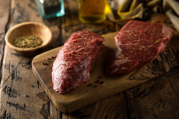 Raw beef steaks on a wooden desk