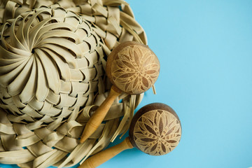 Vacation souvenirs. Hat and maracas from palm leaves on blue background