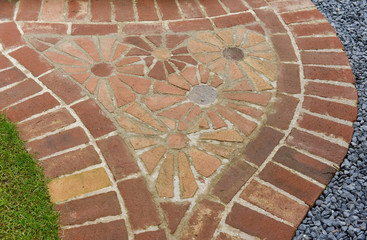 Curved garden red brick path with red brick flower mosaic