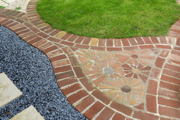 Curved garden red brick path with red brick flower mosaic