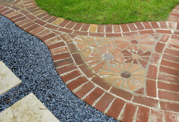 Curved garden red brick path with red brick flower mosaic