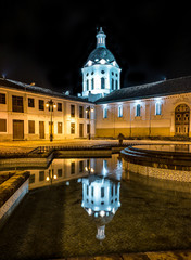 Saint Sebastian church at night, illuminated, with the dome of the church reflected in the water fountain. Cuenca, Ecuador.