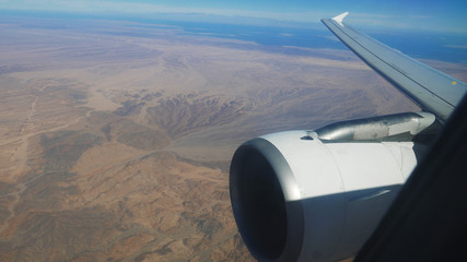 Airplane flies over the mountainous desert of Egypt near Red Sea
