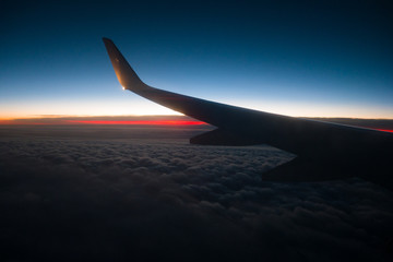 Scenic dawn in the sky above the clouds - view from the window of an airplane