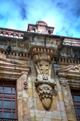 Cuenca, Ecuador, November 2013: Details of the old municipality building in downtown, with it's artistic decorations and salmon color.