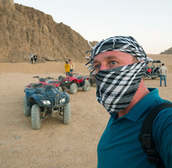 Tourist while riding a quad bike in the Egyptian mountain desert near the resort of Sharm El Sheikh in South Sinai 