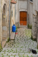 A narrow street between old buildings in the medieval town of Cusano Mutri, in the province of...