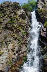 Obraz premium fast waterfall among a rocky gorge in the mountains