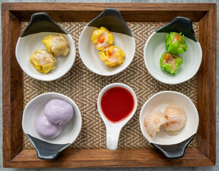 Dim Sum set served with special dipping sauce on a wooden tray