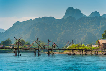 Beautiful mountain scenery at Vang Vieng with a local village lady hiding under her sun umbrella...