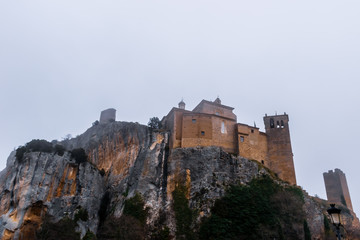 Fototapeta na wymiar A bottoms-up picturesque view of the medieval castle of Alquézar (Huesca, Spain) on a cliff in the Spanish Pyrenees on a cloudy winter morning