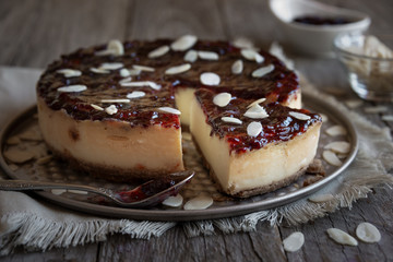 Homemade delicious cheesecake with fruit jam and almonds