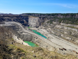 Production of graphite. Deep pit under the open sky.