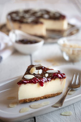 Homemade delicious cheesecake with fruit jam and almonds