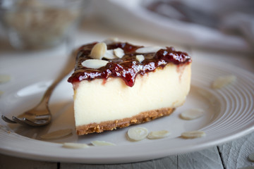 Homemade delicious cheesecake with fruit jam and almonds