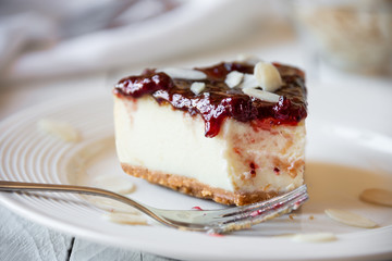 Homemade delicious cheesecake with fruit jam and almonds