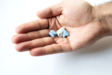 different pills in male hand isolate closeup
