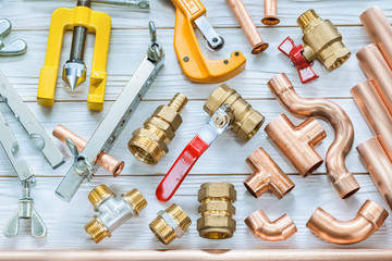 plumbing tools copper pipes pipe cutter fittings valwes flaring clamps on white wooden boards
