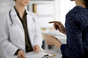 Doctor and patient discussing current health examination while sitting in clinic. Perfect medical...