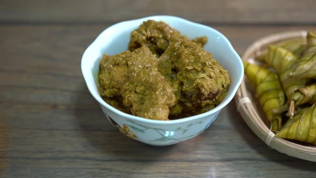Cinematic shot of ketupat palas and chicken rendang, traditional malay cuisines typically served during eid