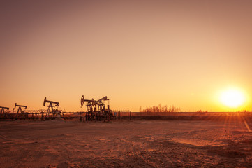 Oil pump rig. Oil and gas production. Oilfield site. Pump Jack are running. Drilling derricks for fossil fuels output and crude oil production. War on oil prices. Global coronavirus COVID 19 crisis.