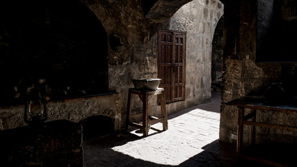 antique water filter inside an old kitchen with medieval stove in famous monastery of santa catalina. scenic light and shadows. gray stones in tranquil colonial heritage