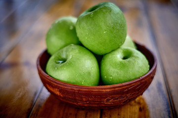 green apples on the table after rain