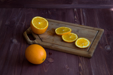 orange and knife on a wooden board. cut orange