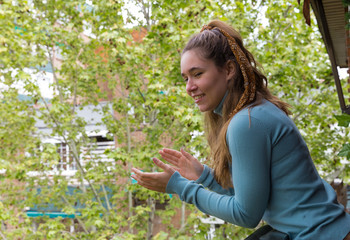 Young woman applauding on the balcony