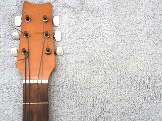 Detail of tuning head for old acoustic guitar. Head neck of classic acoustic guitar on gray...