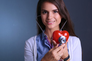Doctor woman with stethoscope examining red heart