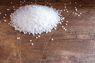 White plastic beads on wood  background, Polymers bead or polymer resin, polymer pallet, Product...