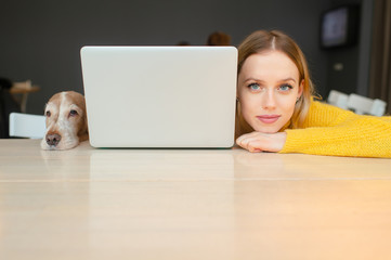 Closeup portrait of blonde woman head and head of her cocker spaniel dog lying togther on a table...