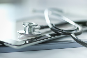 Medical equipment: stethoscope and tablet on white background. Medical equipment