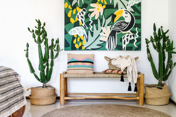 Wooden bench seat, cozy cushions, plaid, carpet on floor and cactus plants
