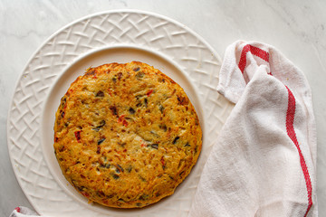 Spanish potato omelette on white plate over white marble table. Typically Spanish vegetarian food. 
