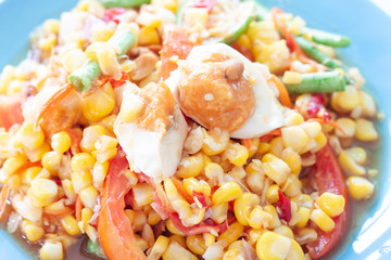 Closeup Corn salad and Salted egg in blue plate, Thai people call Som Tam Khow Phod Kai Khem.