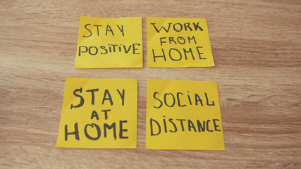 Four colorful remark stickers on wooden table saying motivational phrases for business, work from home, distant jobs, positive attitude. Encouragement.