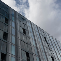 The sky reflected in the glass windowed facade of Hartley House, Bermondsey, London, England