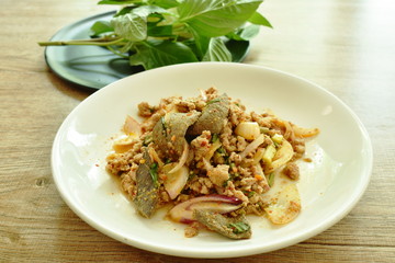 Thai spicy minced pork salad and fresh vegetable on plate