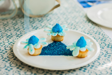 Blue and white tasty cakes like flowers on white plate