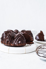 Homemade Chocolate bundt cake with melted chocolate on white background.Close up view, selective focus