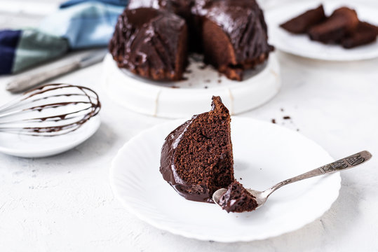 Homemade Chocolate bundt cake with melted chocolate on white background.Close up view, selective focus