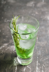 Sweet tequila based green cocktail with tarragon and rosemary. Selective focus. Shallow depth of field.
