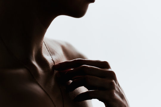 Dark silhouette of a girl with a beautiful collarbone on a white background