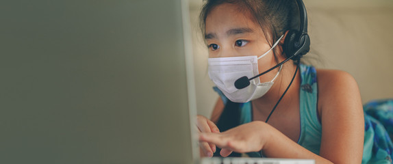 asian girl student wear headphone watch webinar listen online course communicate by conference video call. . Homeschooling and distance learning ,online ,internet protect from COVID-19 viruses.