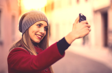 Portrait of  blonde girl, taking selfie photo with smartphone.